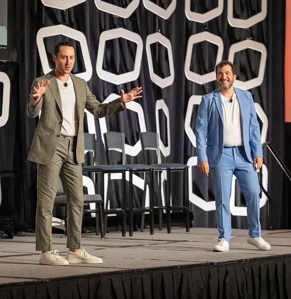 two person on the stage speaking in front of audience