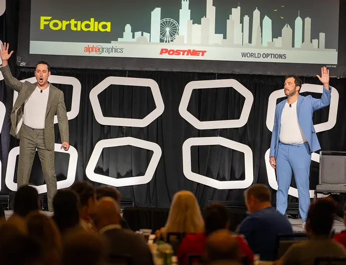 speakers o the stage waiving at the audience